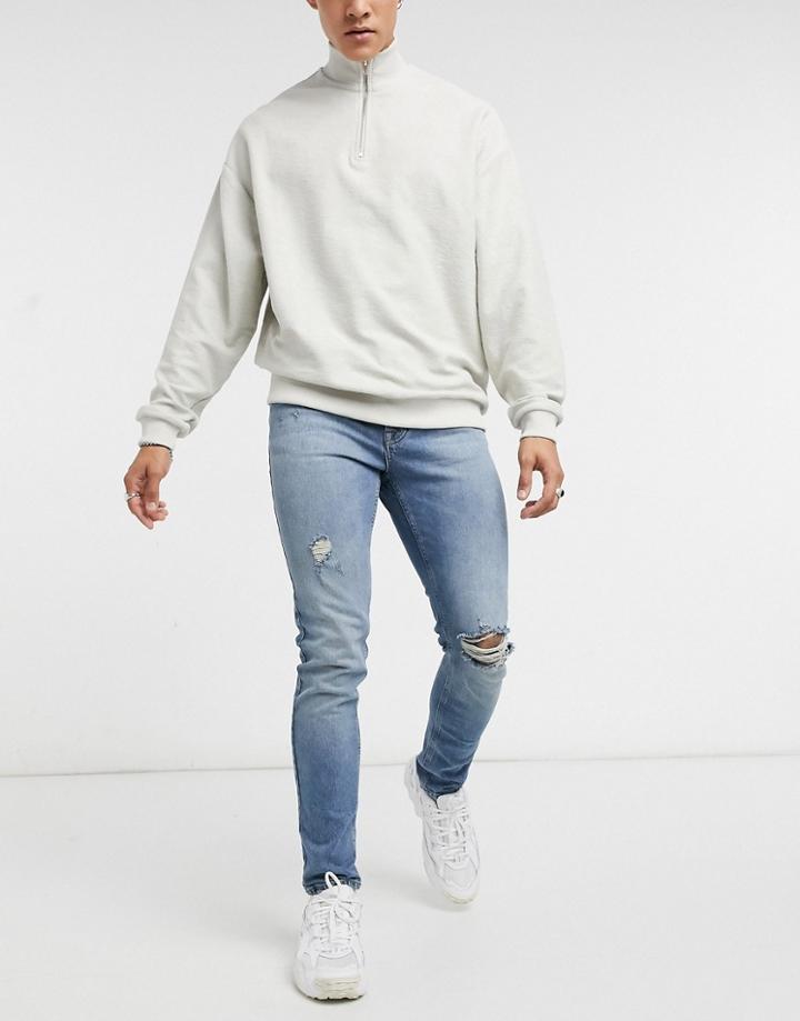 Asos Design Skinny Jeans In Vintage Mid Wash Blue With Knee Rip And Abrasions