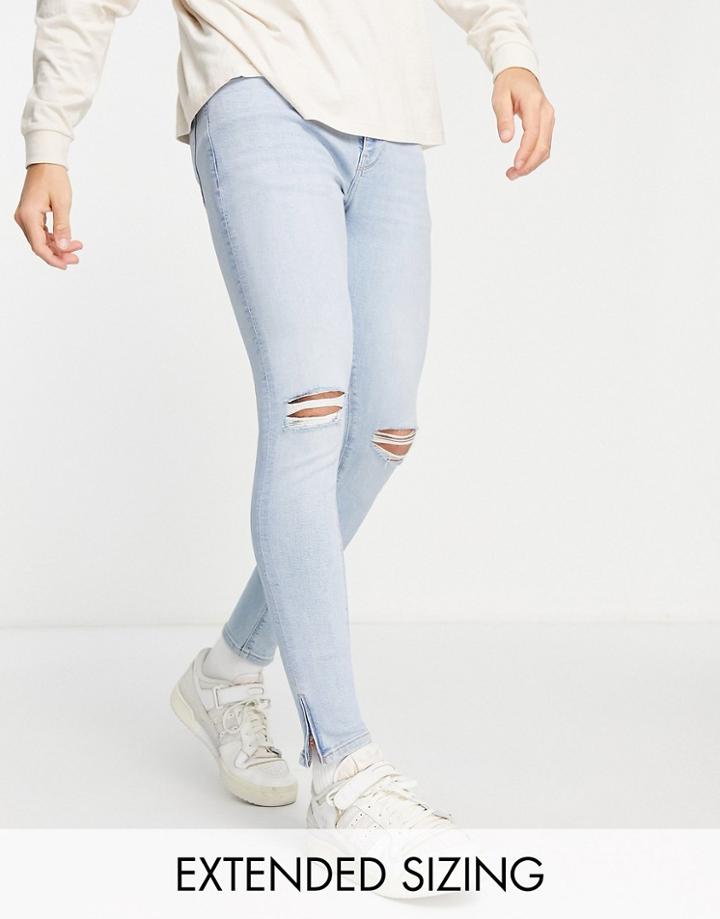 Asos Design Spray On Jeans In Power Stretch In Light Wash With Knee Rips And Zip Hem-blue