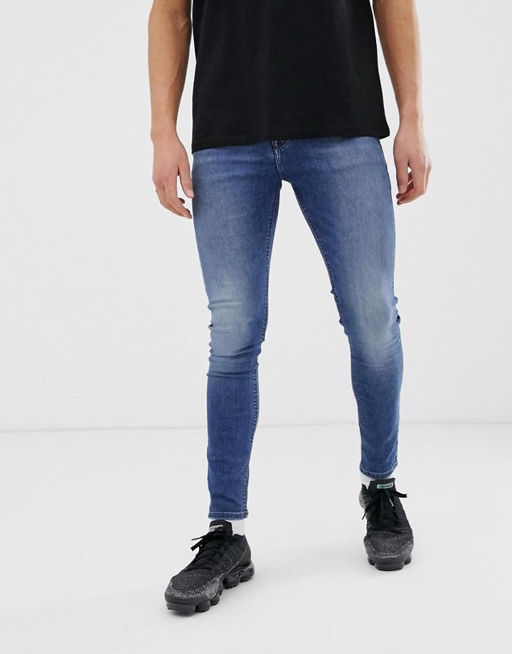 Asos Design Spray On Jeans In Power Stretch Denim In Mid Wash Blue