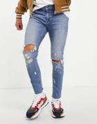 Asos Design Skinny Jeans In Mid Wash With Knee Rips And Raw Hem-blues