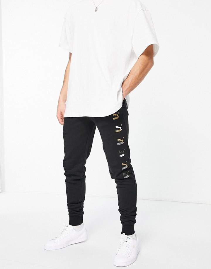 Puma All Over Logo Print Sweatpants In Black And Gold
