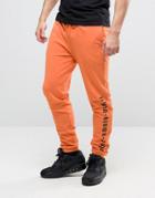 Asos Skinny Joggers With Gothic Text In Orange - Orange