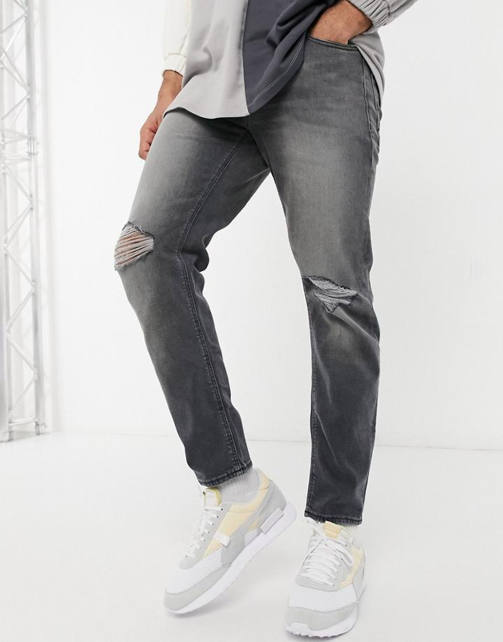 Asos Design Tapered Jeans With 'less Thirsty' Wash In Black With Knee Rips