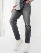 Asos Design Tapered Jeans With 'less Thirsty' Wash In Black With Knee Rips