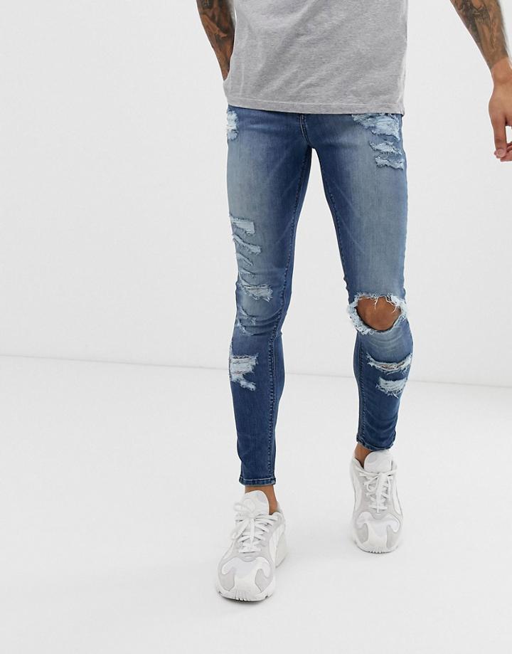 Asos Design Spray On Jeans In Power Stretch With Heavy Rips In Mid Wash Blue - Blue