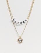 Asos Design Pack Of 2 Necklaces With Crystal Gem Heart And Cherry Letter Pendants In Gold Tone - Gold