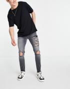 Asos Design Skinny Jeans With Heavy Rips And Raw Hem In Washed Black