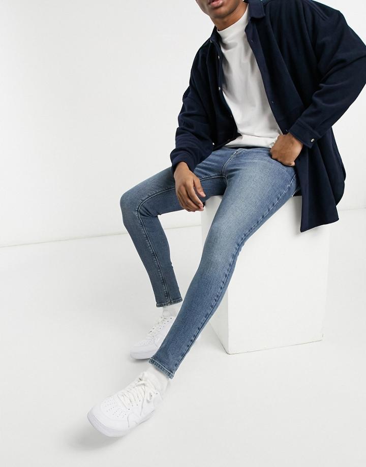 Asos Design Vintage Look Spray On Jeans With Power Stretch In Mid Blue-blues