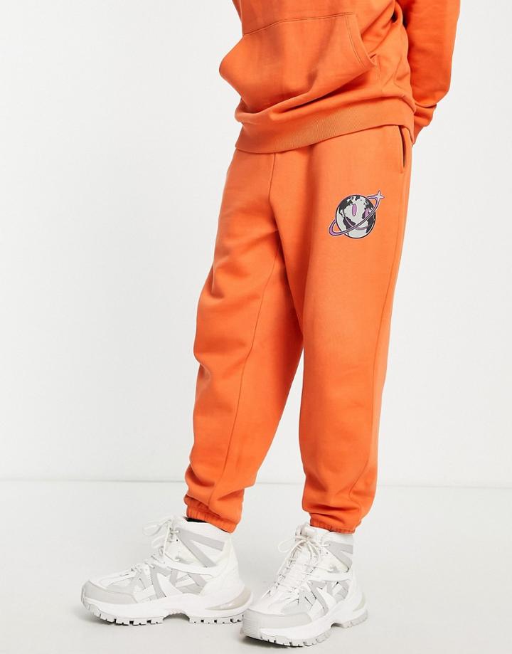 Asos Design Oversized Sweatpants In Orange With World Logo Print - Part Of A Set