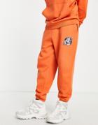 Asos Design Oversized Sweatpants In Orange With World Logo Print - Part Of A Set