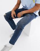 Asos Design Tapered Jeans In Mid Wash Blue With Abrasions