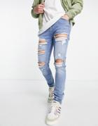 Asos Design Skinny Jeans In Mid Blue With Heavy Rips