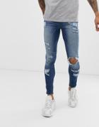 Asos Design Spray On Jeans In Power Stretch With Heavy Rips In Mid Wash Blue