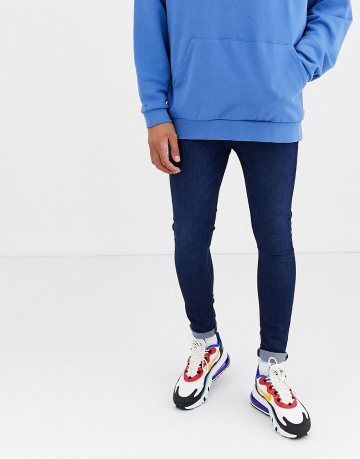 Asos Design Spray On Jeans In Power Stretch Denim In Dark Wash Blue